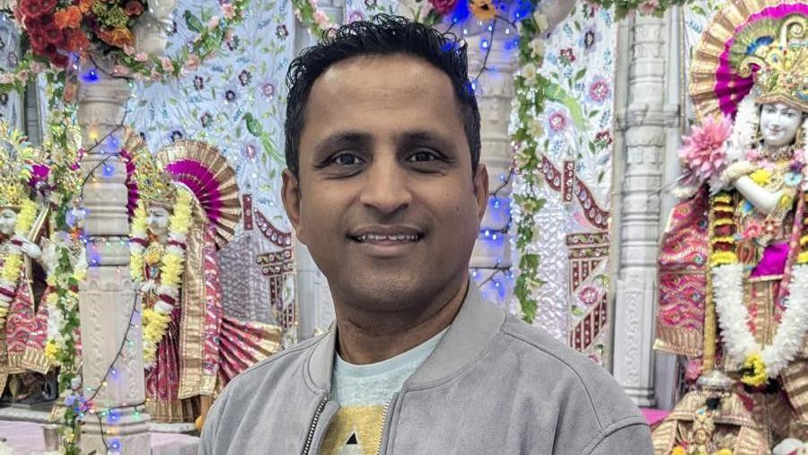 A head and shoulders shot of Kash Patel taken inside a brightly decorated Hindu temple 