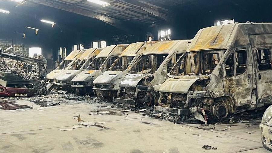 A series of destroyed buses lined up side by side.