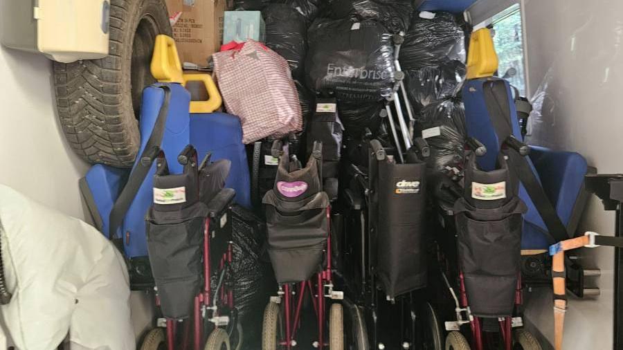 Medical supplies, including a large amount of wheelchairs, bags, items and stretchers in the back of an ambulance. 