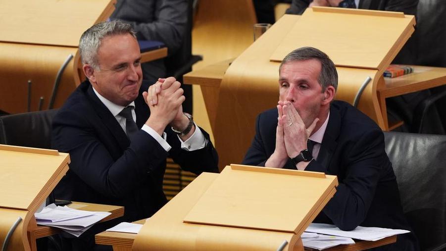 Alex Cole-Hamilton and Liam McArthur react in the Scottish Parliament after the results of the assisted dying bill are revealed