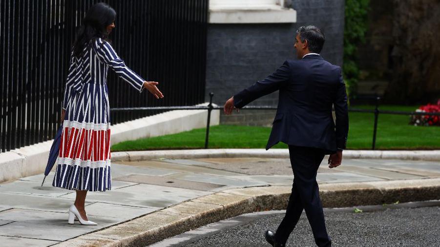 Outgoing British Prime Minister Rishi Sunak and wife Akshata Murty reach to hold hands, after his speech outside Number 10 Downing Street,