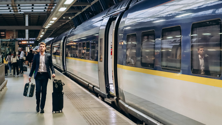 Man in suit drags suitcase alongside Eurostar train