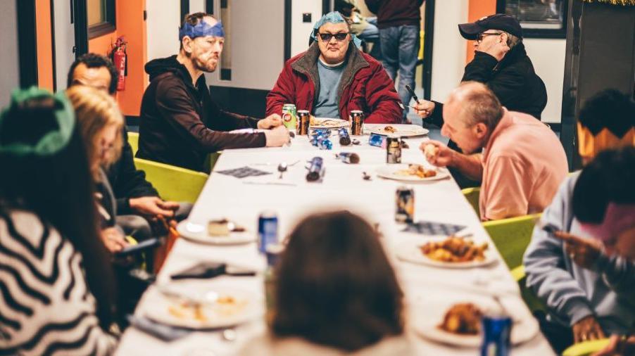 Cleientiaid mewn hetiau yn mwynhau'r wledd