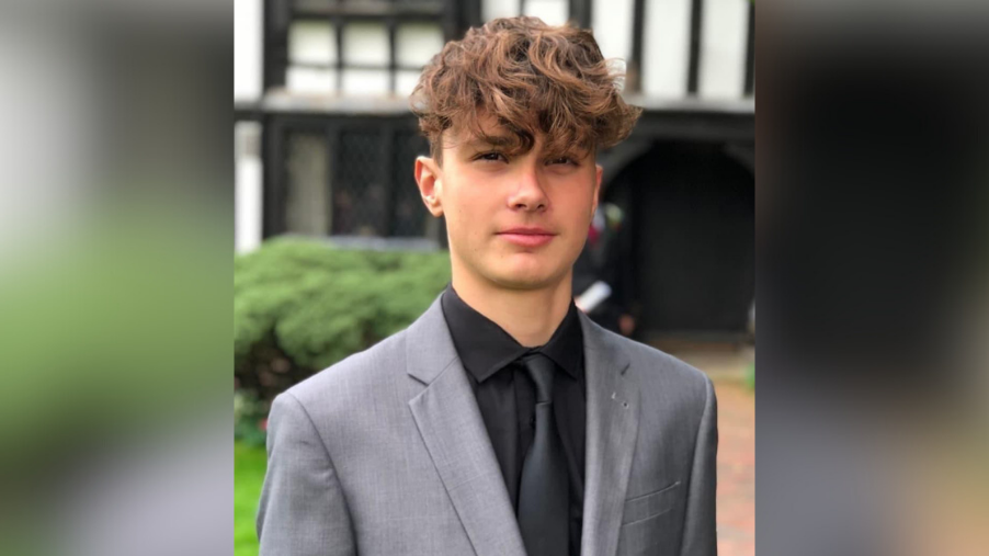 Ethan Treharne in a suit, looking at the camera. He is outside.