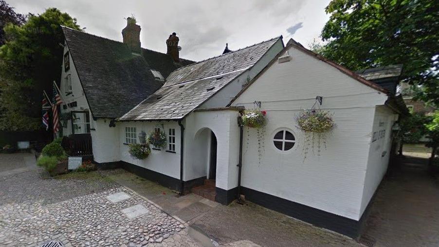 The Bells of Peover pub, with American and UK flags flying outside