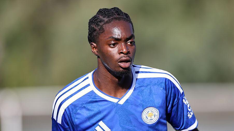 A teenage footballer wearing a blue Leicester City shirt