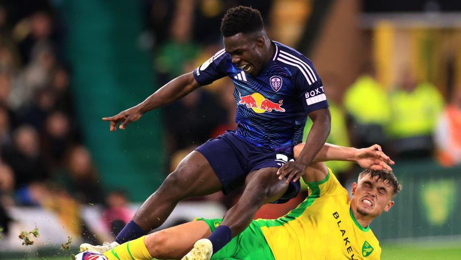 Wilfried Gnonto and Callum Doyle slide for the ball during Norwich v Leeds in September 2024