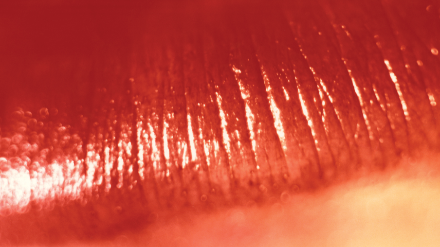 Close-up of a bottom lip with red lipstick on it