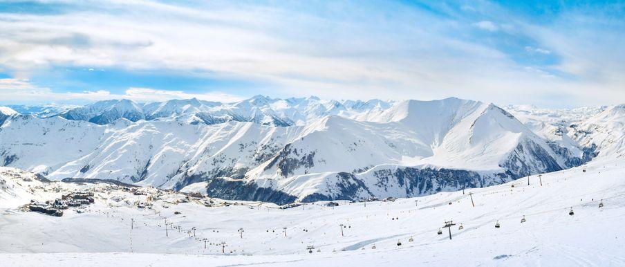 A panoramic view of Gudauri ski resort showing a mountain range covered in snow