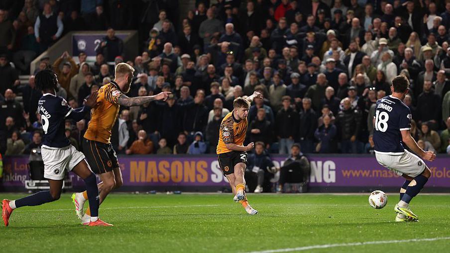 Joe Gelhardt shoots past Millwall defender Ryan Leonard