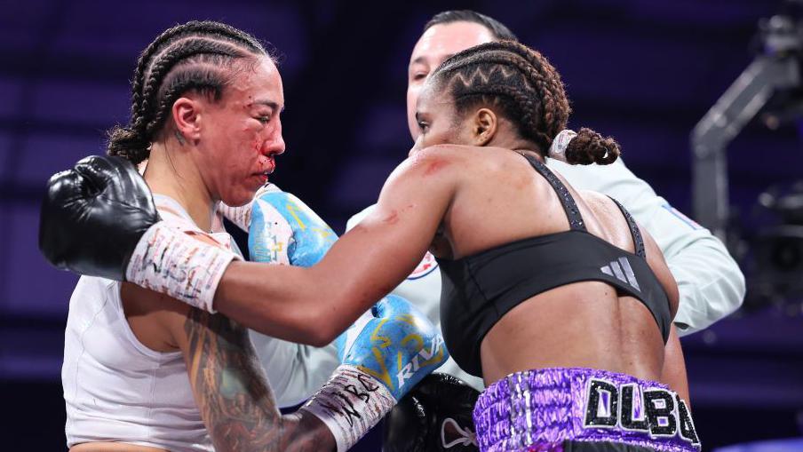 The referee gets in the middle of Caroline Dubois and Jessica Camara, with the Canadian's right eye swollen