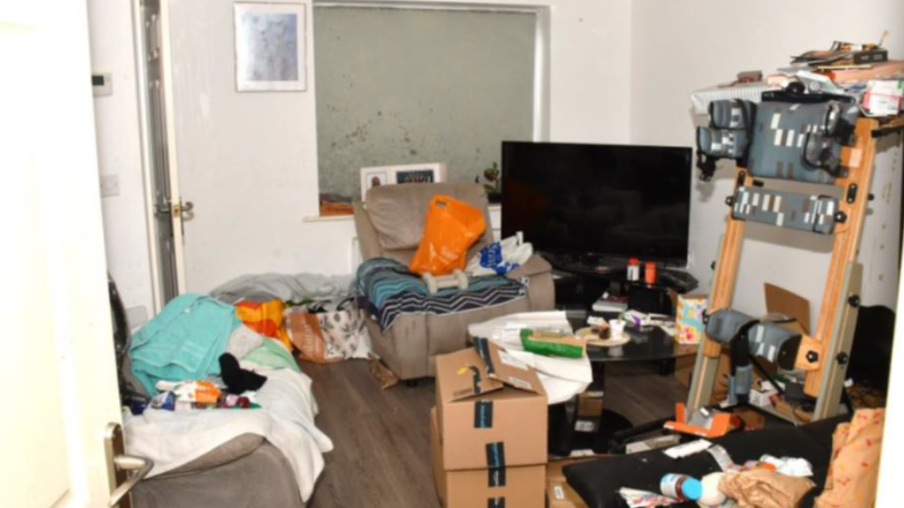 A police evidence photograph of a cluttered room