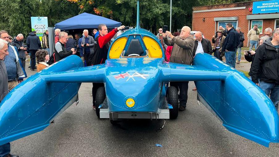 Donald Campbell's Bluebird K7 hydroplane surrounded by people taking photographs