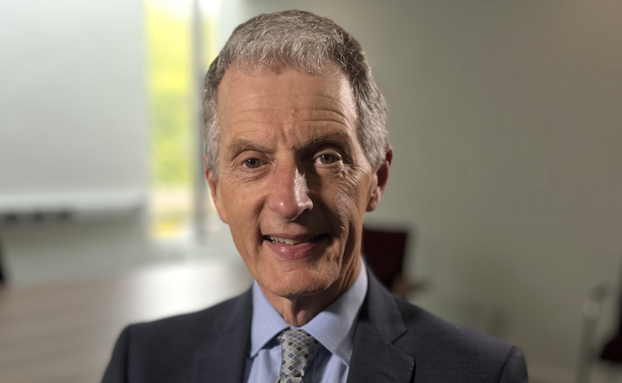 Prof David Maguire smiling at the camera. He is wearing a suit, a blue shirt and a tie