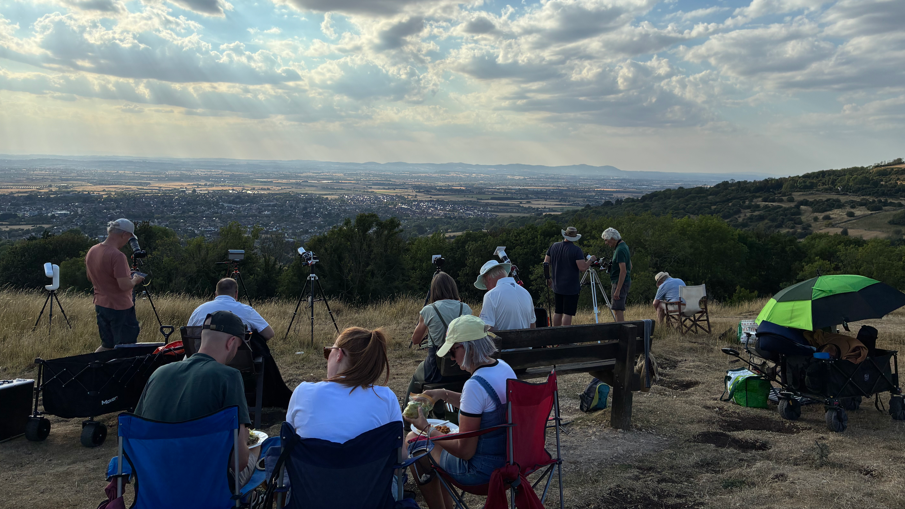 People are sat on chairs while on a large hill