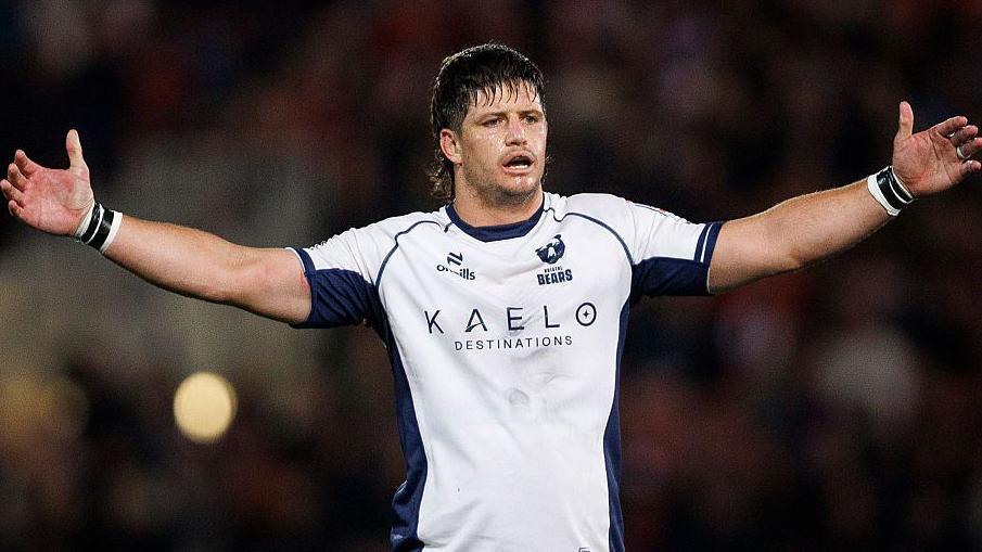 Benhard Janse van Rensburg lifts his arms in the air while in action for Bristol Bears