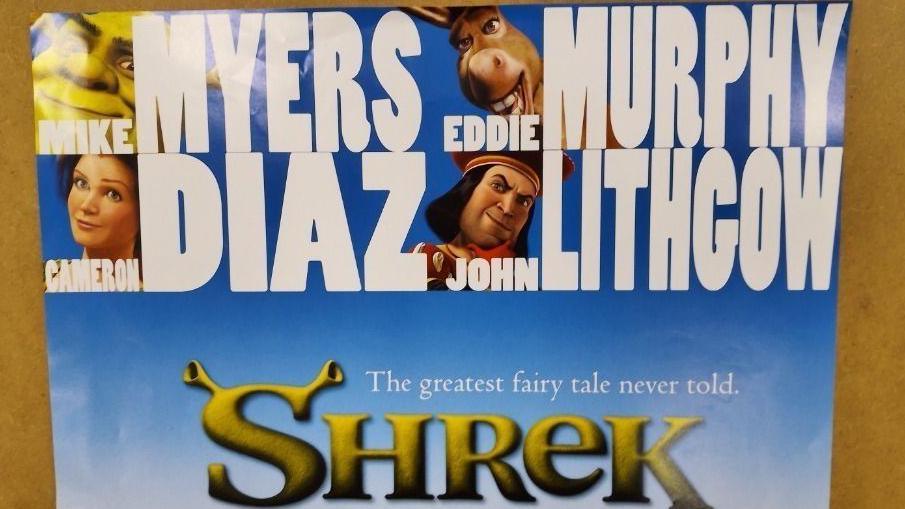 A film poster for Shrek. It features the names of the cast, which includes Mike Myers, Eddie Murphy, Cameron Diaz and John Lithgow, at the top of poster alongside the carton characters. In the middle of the poster, it reads: "The greatest fairy tale never told. Shrek."