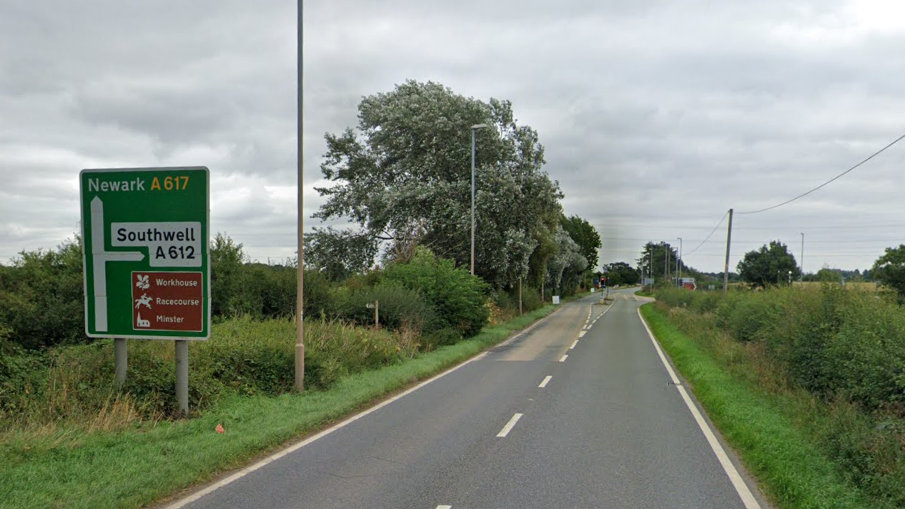 A streetview of the A617 with a road sign on the left showing Newark ahead and Southwell to the right