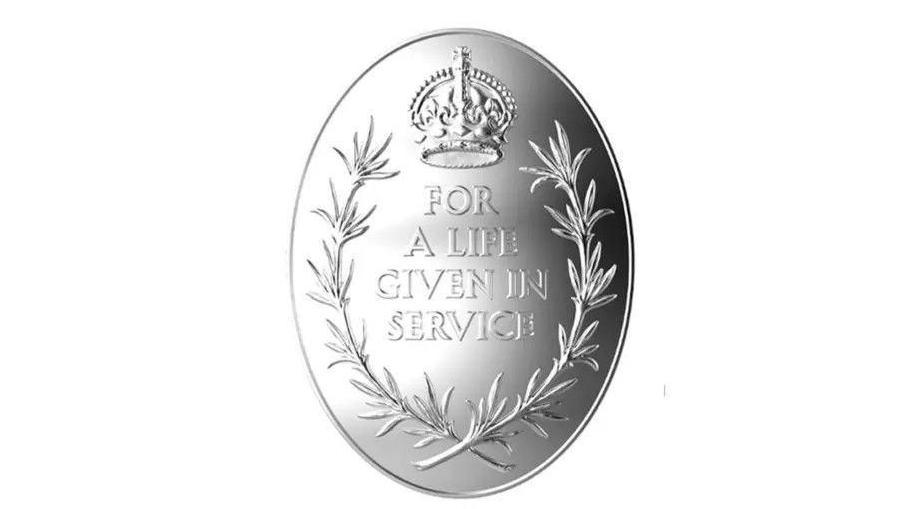 The Elizabeth Emblem - a silver medal with a rosemary wreath surrounding a Tudor Crown and the inscription "For A Life Given In Service".