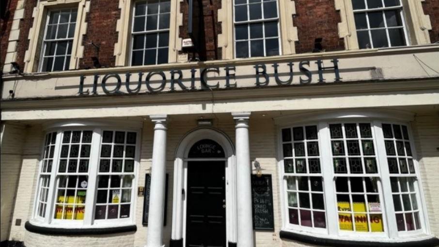 The outside of the Grade II listed Liquorice Bush pub in Pontefract. It has white pillars either side of the main entrance, with several windows on both the ground and first floor.