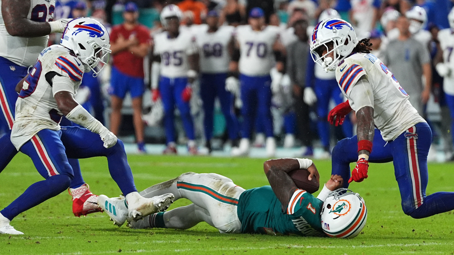 Miami Dolphins quarterback Tua Tagovailoa bangs his head on the turf after being tackled by the Buffalo Bills' Damar Hamlin