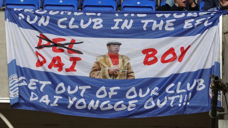 A banner is seen protesting the ownership of Reading FC prior to the Sky Bet League One match between Reading and Northampton Town at Select Car Leasing Stadium on March 29, 2024 in Reading.