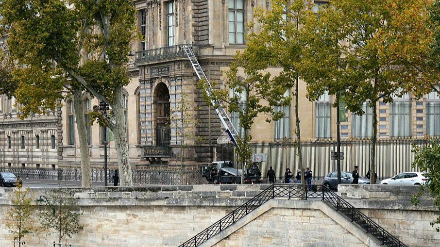 French police officers stand next to a furniture elevator used by robbers to enter the Louvre Museum