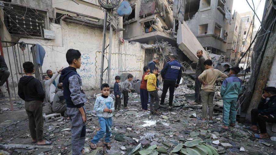 Palestinians inspect damage to a building hit in an Israeli air strike, in the Sheikh Radwan neighbourhood of Gaza City, in northern Gaza (21 November 2024)