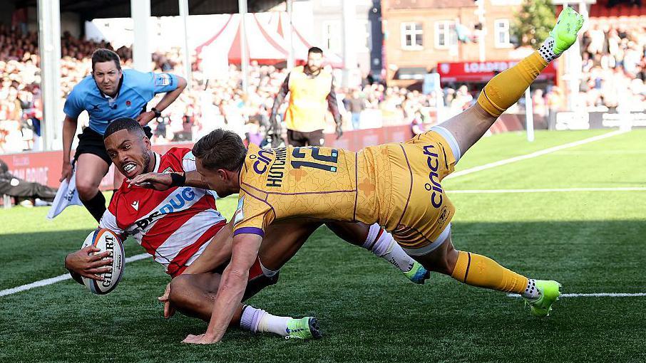 Northampton Saints player Rory Hutchinson tackles Gloucester's Ben Loader to prevent a try.
