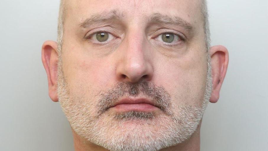 Police mugshot of Lee Smith, who has shaved grey hair and grey stubble.