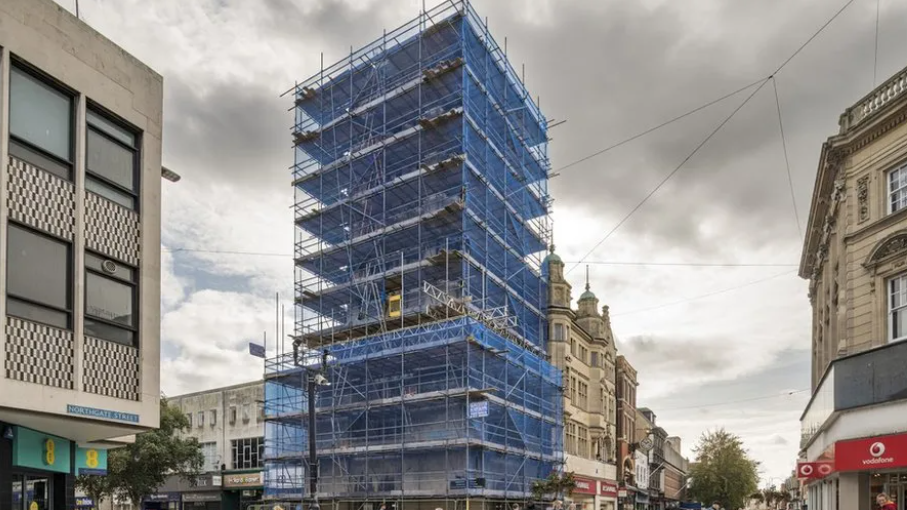 The tower covering in blue scaffolding.