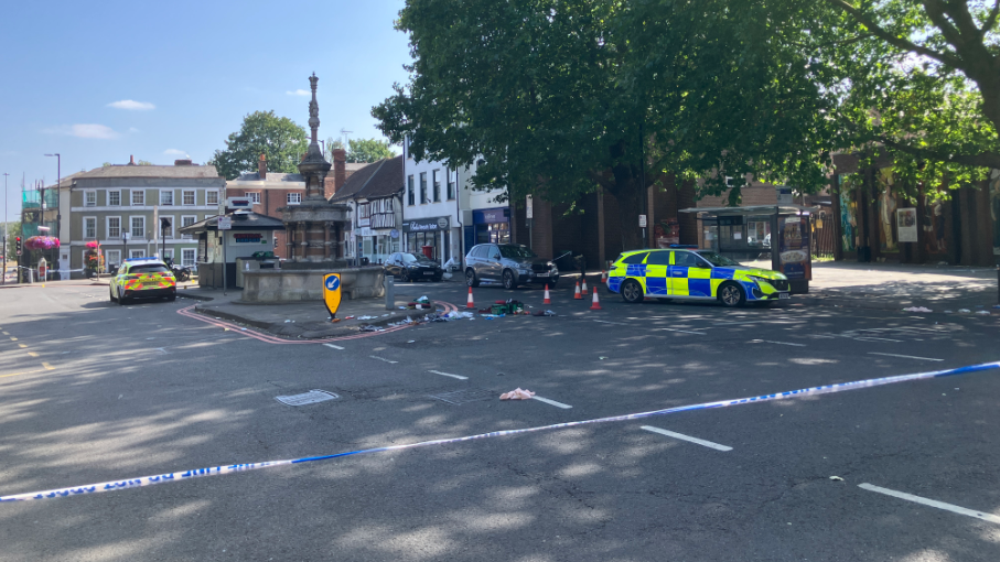 Street view of St Mary's Butt in Reading with two police cars and police tape to cordon off the road.