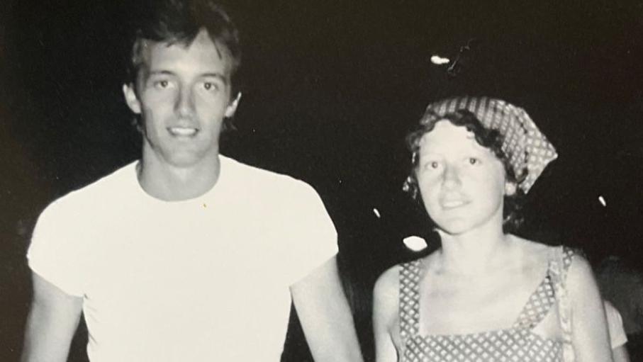 A black and white photo of a man and a woman. They are smiling.
