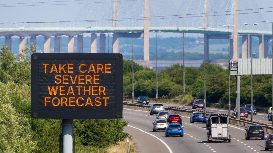 Heat warning matrix sign with the Severn Bridge in the background