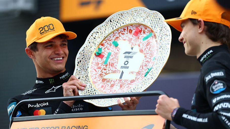 Lando Norris smiling with McLaren team-mate Oscar Piastri