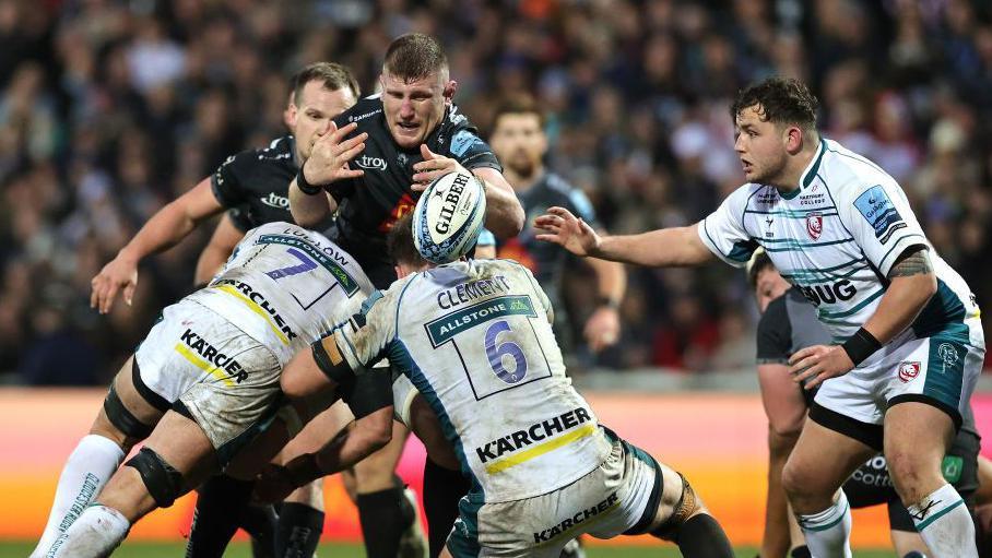 Exeter forward Jacques Vermuelen has the ball under pressure from Gloucester defenders