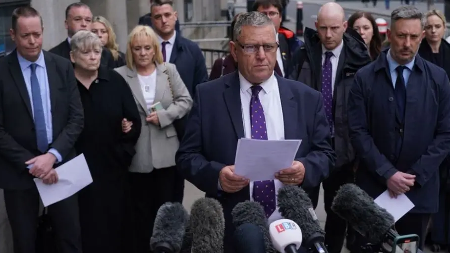 Gary Furlong, the father of victim James Furlong, watched by his wife Jan, and other victims' family members talks to the press outside the Old Bailey, central London, after the inquest concluded in April