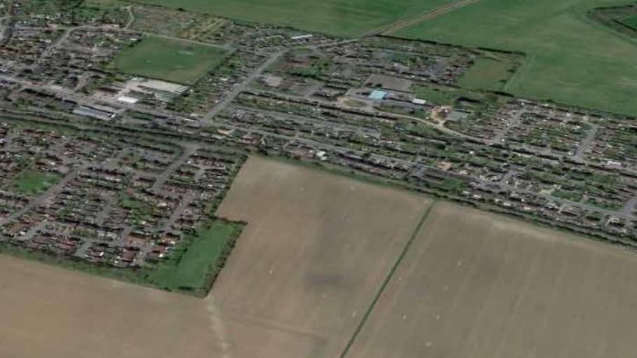 town layout from above, fields in foreground and background