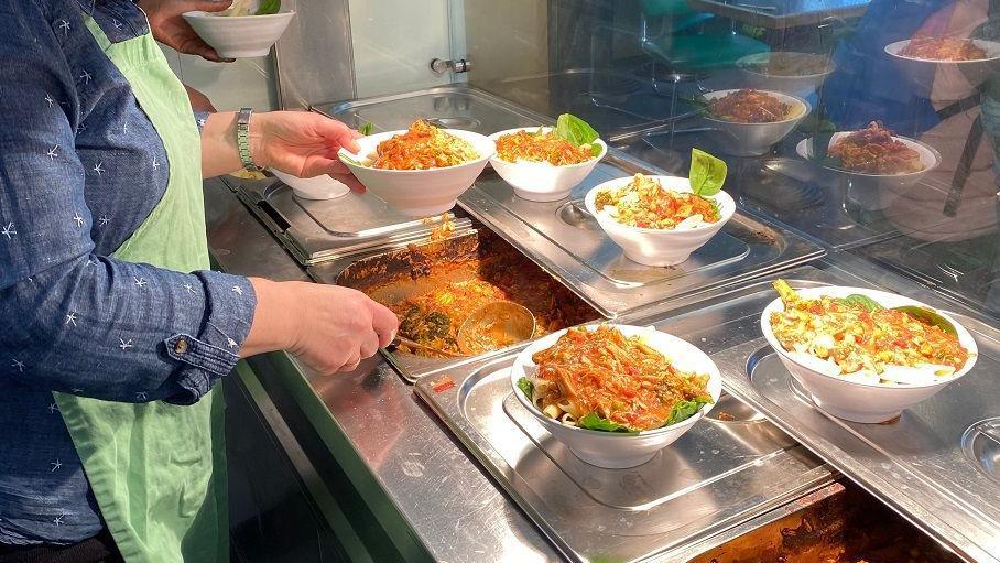 A woman serving bowls of hot food at the Wild Goose Centre in Bristol