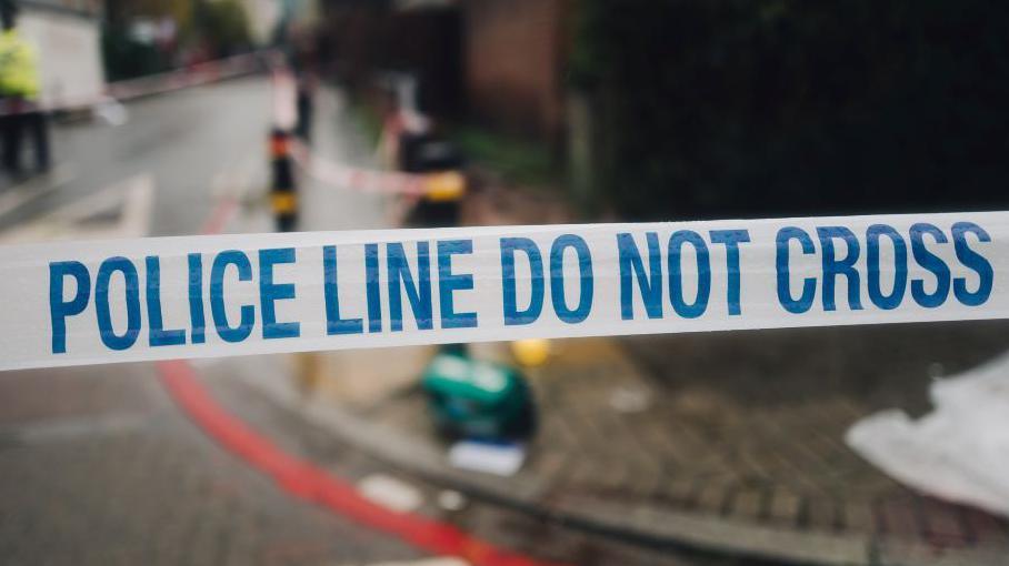 Police tape in a street covering a crime scene