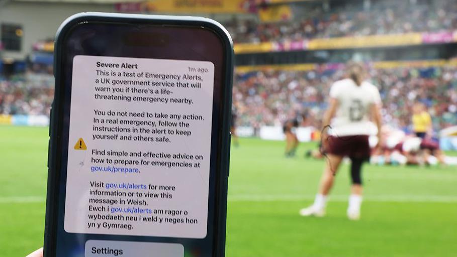 A phone screen is seen in the foreground at the ground during the Ireland vs New Zealand Women's World Cup game in Brighton.