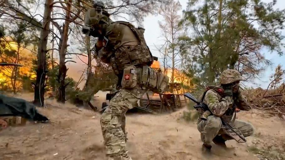 Russian soldiers cover their ears as a Giatsint-B field gun is fired towards Ukrainian positions somewhere in Russia, taken 19 September