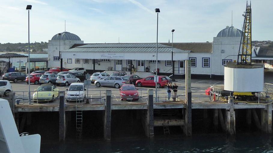 A view of the Ryde Pier Head car park from a passing ferry with a white train station building in the background