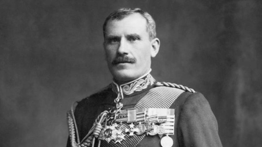 Sir Hector is pictured in a black and white photograph wearing a ceremonial uniform. There is a row of medals pinned to his chest.