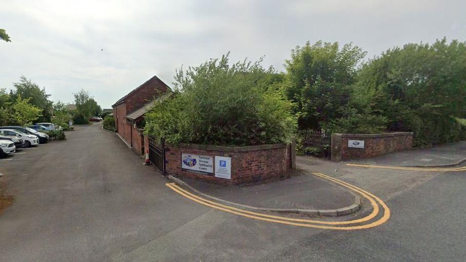 The entrance to the religious retreat with cars parked inside