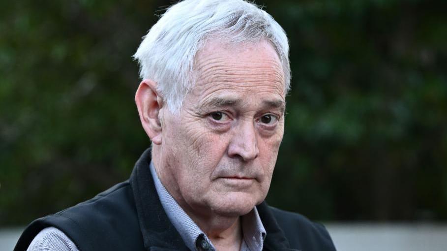 Ian Wilkinson wearing a dress shirt and a black vest