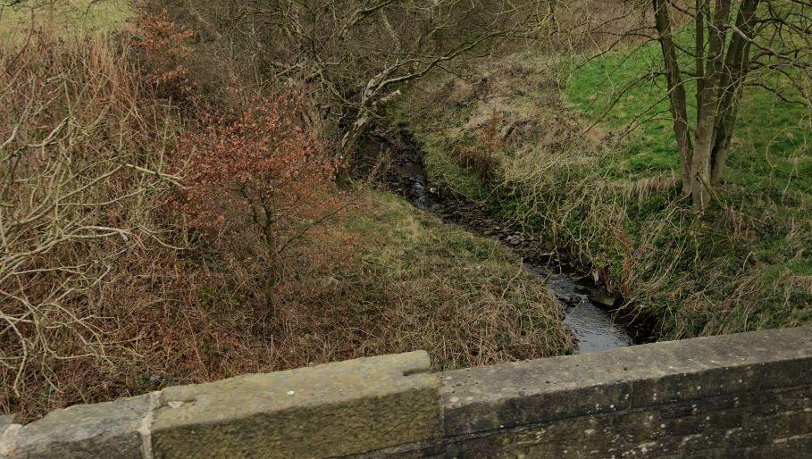 An image of Cottingley Beck taken from a road bridge above the water