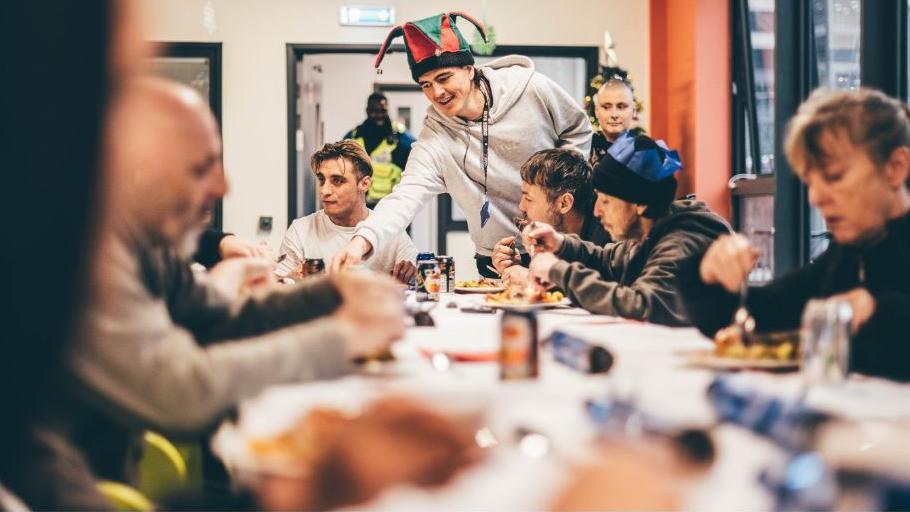 Staff yn arlwyo bwyd i'r digartref yn yr Huggard