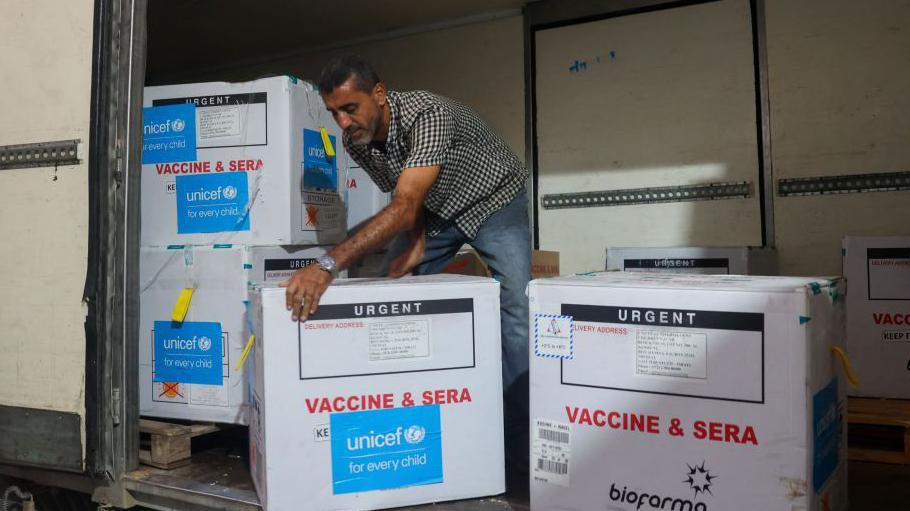 A worker unloads a shipment of polio vaccines at a depot belonging to Gaza's health ministry on 25 August