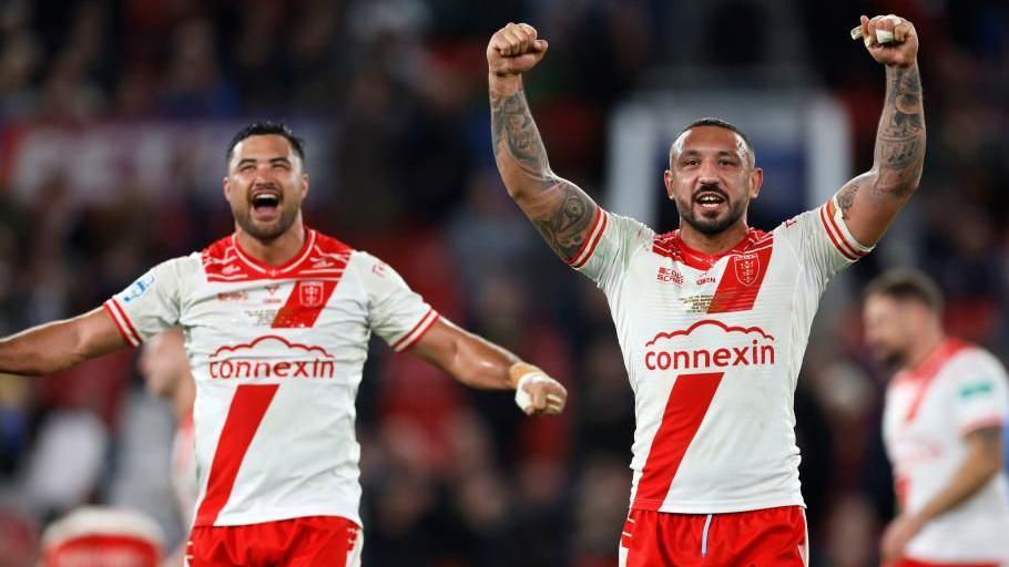 Two Hull KR players, wearing red and white uniforms, cheer in celebration.